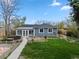 Backyard featuring a concrete patio, garden beds and grass at 835 S Shoshone St, Denver, CO 80223