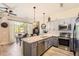 Open concept kitchen with stainless steel appliances, gray cabinets, granite countertops, and a view of the dining area at 5401 S Park Terrace Ave # 109A, Greenwood Village, CO 80111