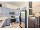 Updated kitchen with stainless steel appliances, gray cabinets, granite countertops, and a stylish tile backsplash at 5401 S Park Terrace Ave # 109A, Greenwood Village, CO 80111