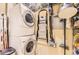 Practical laundry room features stacked washer and dryer and a ladder, maximizing space and functionality at 5401 S Park Terrace Ave # 109A, Greenwood Village, CO 80111
