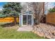 Backyard features a small blue storage shed with sliding glass doors, surrounded by stones and landscaping at 6726 S Franklin St, Centennial, CO 80122