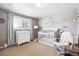 Bright Bedroom featuring a white crib, changing table, glider, and mountain-themed decor, creating a serene and inviting space at 6726 S Franklin St, Centennial, CO 80122