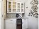 Butlers pantry with wine fridge and glass cabinets to display fine wines at 6726 S Franklin St, Centennial, CO 80122