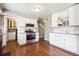 Well-lit kitchen featuring stainless steel appliances, white cabinets, and wood flooring at 6726 S Franklin St, Centennial, CO 80122