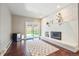 Living room with white brick fireplace, sliding doors to yard and wood floors at 6726 S Franklin St, Centennial, CO 80122