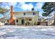 Exterior featuring a well-maintained backyard with a patio, hot tub, manicured lawn, shed, and snow at 7631 Oak St, Arvada, CO 80005