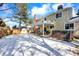 Exterior featuring a well-maintained backyard with a patio, hot tub, lush lawn, snow, and shed at 7631 Oak St, Arvada, CO 80005