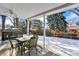 Inviting covered back patio featuring a dining set, perfect for outdoor entertaining near the snow-covered yard at 7631 Oak St, Arvada, CO 80005