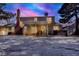 Backyard view of a well-lit home featuring a covered patio, chimney, and a hot tub for relaxation at 7631 Oak St, Arvada, CO 80005