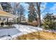 Large backyard with a covered patio, and snow-covered lawn, ideal for outdoor activities and relaxation at 7631 Oak St, Arvada, CO 80005