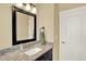 Elegant bathroom featuring granite countertop, a black-framed mirror and modern fixtures at 7631 Oak St, Arvada, CO 80005