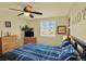 Comfortable bedroom featuring blue bedding, a ceiling fan, and a dresser at 7631 Oak St, Arvada, CO 80005