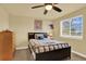 Cozy bedroom features a ceiling fan, dresser, and twin-size bed with striped and blue bedding at 7631 Oak St, Arvada, CO 80005