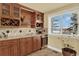 Wet bar featuring custom wood cabinets, wine racks, a granite counter top and beverage refrigerator at 7631 Oak St, Arvada, CO 80005