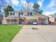 Traditional home with a two-car garage, well-kept lawn, and inviting front porch at 7631 Oak St, Arvada, CO 80005