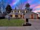 Charming two-story home with a brick facade, well-manicured lawn, and a three-car garage on a nicely landscaped lot at 7631 Oak St, Arvada, CO 80005