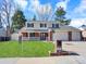 Charming two-story home with well-maintained lawn, front porch, and two-car garage at 7631 Oak St, Arvada, CO 80005