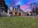 Two-story home with green lawn and beautiful landscaping under a colorful sky at 7631 Oak St, Arvada, CO 80005