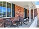 Inviting front porch with brick facade, rocking chairs, and decorative elements at 7631 Oak St, Arvada, CO 80005