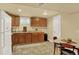 Finished basement kitchenette with wooden cabinets and appliances, plus a dining table at 7631 Oak St, Arvada, CO 80005