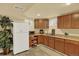 Basement kitchenette with wooden cabinets and appliances at 7631 Oak St, Arvada, CO 80005