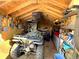 Interior view of a shed featuring four-wheelers, tools, equipment, ample storage, and wooden walls at 7631 Oak St, Arvada, CO 80005