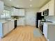 Bright kitchen featuring white cabinets, stainless steel appliances, and wood-look flooring at 2118 S Mobile Way, Aurora, CO 80013