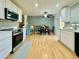 Open kitchen features white cabinets, stainless steel appliances, and a light-filled dining area at 2118 S Mobile Way, Aurora, CO 80013