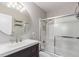 Updated bathroom featuring a modern vanity, a mirror, and a shower with glass doors at 6343 Depew St, Arvada, CO 80003