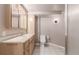 This light wood bathroom includes a vanity, toilet, shower, and great overhead lighting at 6343 Depew St, Arvada, CO 80003