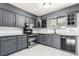 Updated kitchen features stainless steel appliances, custom cabinets, and modern lighting at 6343 Depew St, Arvada, CO 80003