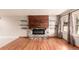 Sunlit living room featuring hardwood floors and a stylish fireplace with floating shelves at 6343 Depew St, Arvada, CO 80003
