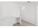 Bright bedroom with white walls, carpeted floor, and built-in desk with cabinets at 6912 Huddersfield Ln, Castle Pines, CO 80108
