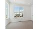 Well-lit bedroom with large windows offering a view of neighboring townhomes at 6912 Huddersfield Ln, Castle Pines, CO 80108