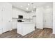 Modern kitchen featuring white cabinets, quartz countertops, stainless steel appliances, and hardwood floors at 6912 Huddersfield Ln, Castle Pines, CO 80108