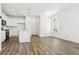 Bright, open-concept living area with hardwood floors, white walls, modern lighting, and an open kitchen at 6912 Huddersfield Ln, Castle Pines, CO 80108