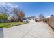 Wide backyard with concrete patio, green grass, and wood fence at 3310 W 95Th Ave, Westminster, CO 80031
