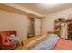 Finished basement bedroom with modern peach accent chair, closet, and updated flooring at 3310 W 95Th Ave, Westminster, CO 80031
