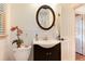 Charming bathroom with a vanity, round mirror, and decorative orchids at 5215 S Washington St, Littleton, CO 80121