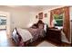 Bedroom featuring a floral patterned queen bed, plush pillows, and wood nightstand at 5215 S Washington St, Littleton, CO 80121