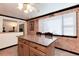 Open concept kitchen island with seating, granite countertop, storage, and lighting at 5215 S Washington St, Littleton, CO 80121