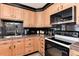 Updated kitchen features light wood cabinets, black backsplash, granite countertops, and stainless steel appliances at 5215 S Washington St, Littleton, CO 80121