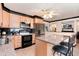 Modern kitchen with an island, black appliances, granite countertops and light wooden cabinets at 5215 S Washington St, Littleton, CO 80121