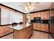 Spacious kitchen featuring an island with drawers, neutral tiling, and warm-toned cabinetry at 5215 S Washington St, Littleton, CO 80121