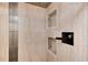 Close-up of the shower featuring luxurious tiling, niche, and bronze shower head at 5215 S Washington St, Littleton, CO 80121