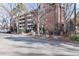 Brick apartment building with balconies and mature trees under a sunny, clear blue sky at 1270 N Marion St # 505, Denver, CO 80218