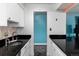 Kitchen featuring white cabinets, black countertops, and stainless steel sink at 1270 N Marion St # 505, Denver, CO 80218