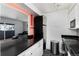 Bright kitchen with stainless steel appliances, white cabinets, black countertops, and a view into the living room at 1270 N Marion St # 505, Denver, CO 80218