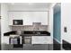 Modern kitchen featuring white cabinets, stainless steel appliances, and sleek black countertops at 1270 N Marion St # 505, Denver, CO 80218