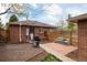 Private backyard with brick patio, gravel area, and mature landscaping at 3700 Zenobia St, Denver, CO 80212